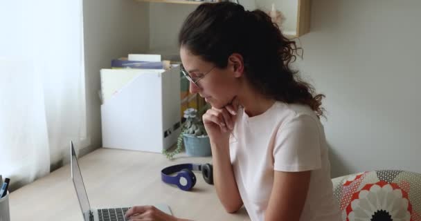 Masada oturan bir kadın dizüstü bilgisayarda çalışıyor. — Stok video