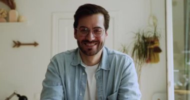 İçerde oturan adam kameraya bakarak canlı video konferansı yapıyor.