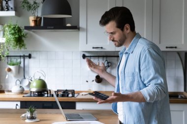 Finansal hata yüzünden kafası karışmış bir adam ödeme yapıyor.