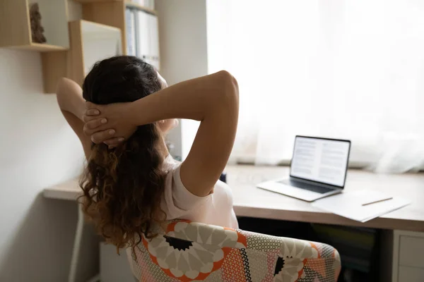 Rückenansicht einer Frau, die sich im Stuhl entspannt und am Computer arbeitet — Stockfoto