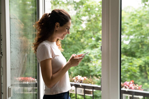 Smiling woman have fun texting on smartphone at home