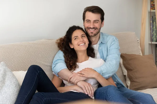 Happy couple relax on sofa dreaming or visualizing