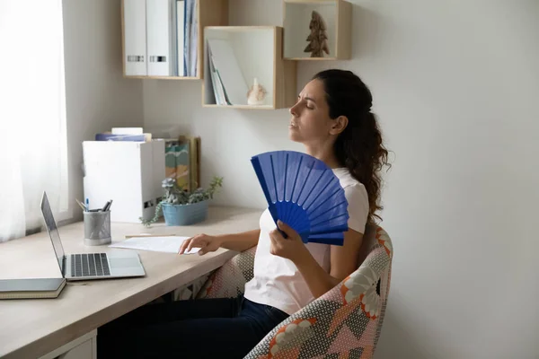 Unwell woman wave with waver suffering from heatstroke