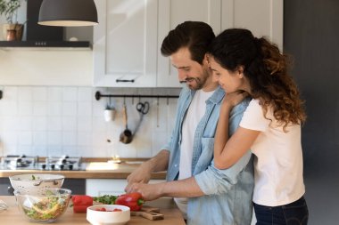 Mutlu çift kiracılar sabahları birlikte yemek pişiriyor.