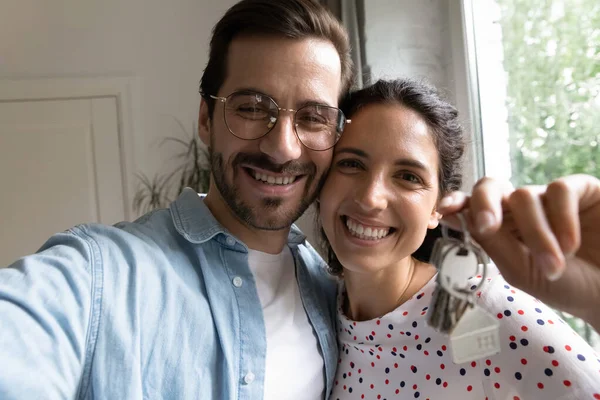 Selfie di coppia sorridente mostra le chiavi della casa che si muovono insieme — Foto Stock