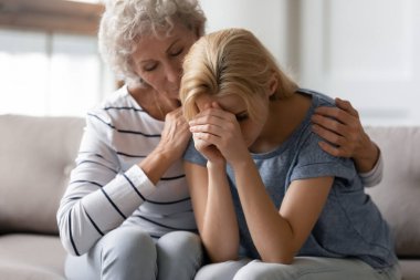 Empatik yaşlı bir kadın kayıp bir kadını kucaklıyor genç bir arkadaşı.