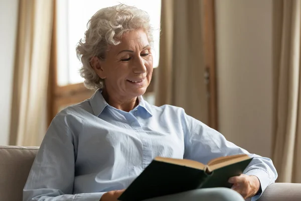 幸せな高齢女性に占領で読書紙の本 — ストック写真