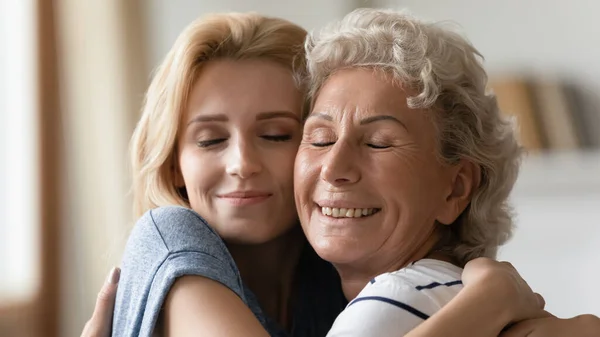 Madre anciana e hija adulta abrazándose con amor y afecto —  Fotos de Stock