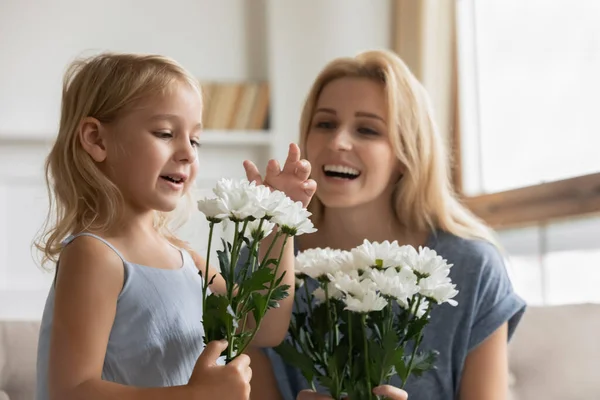 Delighted elder and younger sisters receiving flowers on March 8 — Stock Photo, Image