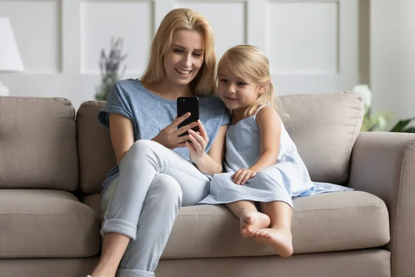 Vuxen syster som förklarar yngre hur man använder mobilappen — Stockfoto