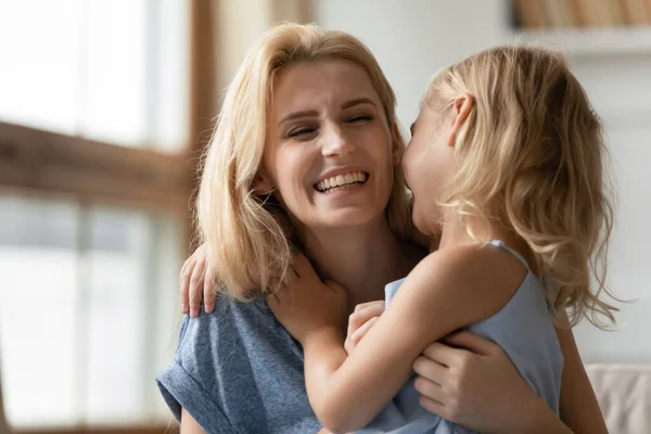 Roztomilá dceruška objímající šťastně se usmívající dospělou matku — Stock fotografie