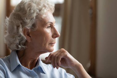 Düşünceli, melankolik, son sınıf öğrencisi, kendini yalnız hisseden bir kadının yan görüntüsü.