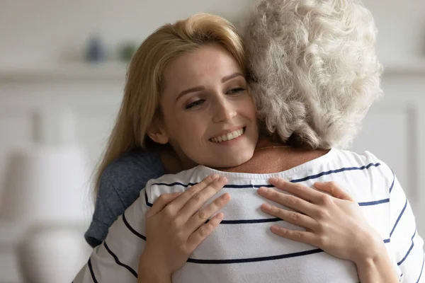 Amour affectueux millénariste fille tenant dans les bras mère d'âge moyen — Photo