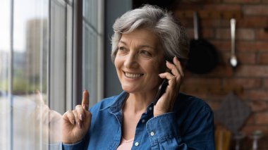 Mutlu bir son sınıf öğrencisi akıllı telefonda keyifli bir konuşma yapar.