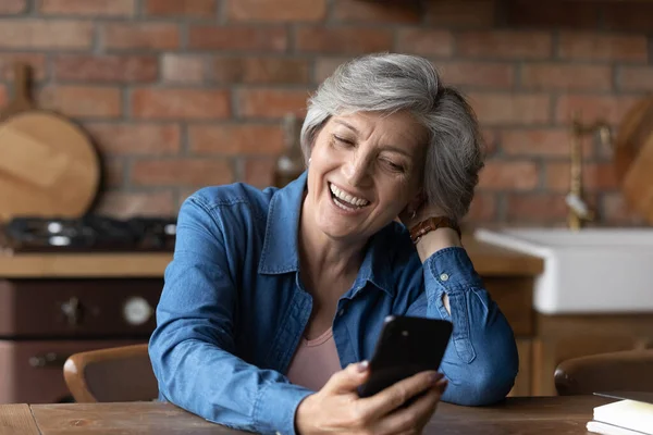 Feliz mujer madura risa viendo vídeo en la celda —  Fotos de Stock