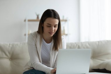Genç bayan evde dizüstü bilgisayarlı tarama ağına bak