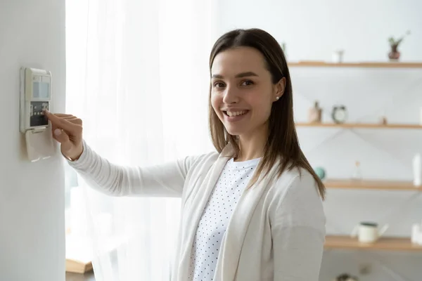 Portrait of smiling woman switch smart home security system