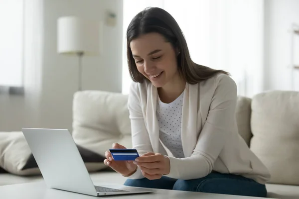 Smiling young woman sue credit card paying online