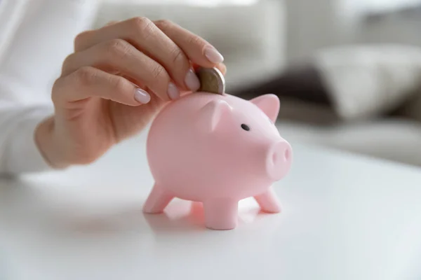 Close up of woman put coin in piggybank saving — Stock Photo, Image