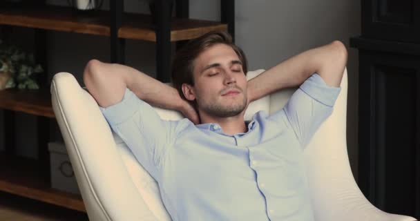 Hombre poner las manos detrás de la cabeza inclinarse en sillón soñando despierto solo — Vídeos de Stock