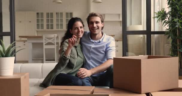 Wife showing keys sitting with husband on couch near boxes — Stock Footage Wife showing keys sitting with husband on couch near boxes Video Clip