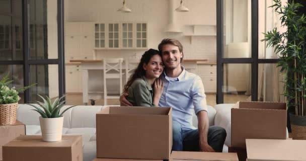 Šťastní majitelé domů sedí na gauči a pózují před kamerou — Stock video