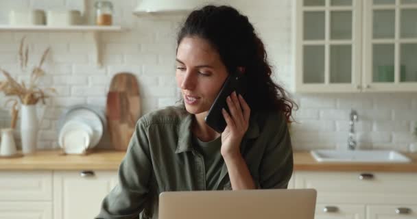 Businesslady mluvit po telefonu s klientem sedí u stolu uvnitř — Stock video