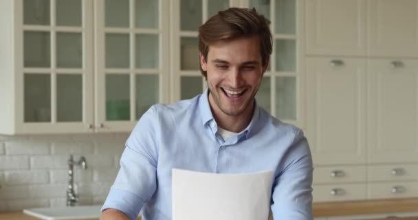 Kerel leest goed nieuws in brief voelt gelukkig vieren succes — Stockvideo