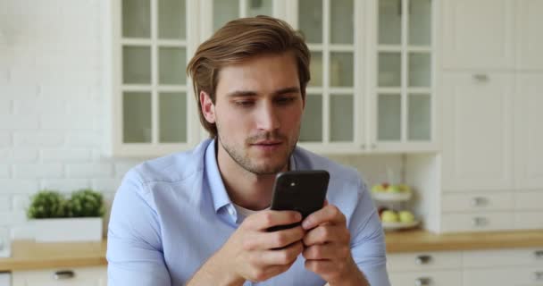 Guy hold in handen smartphone glimlachen genieten van externe online communicatie — Stockvideo