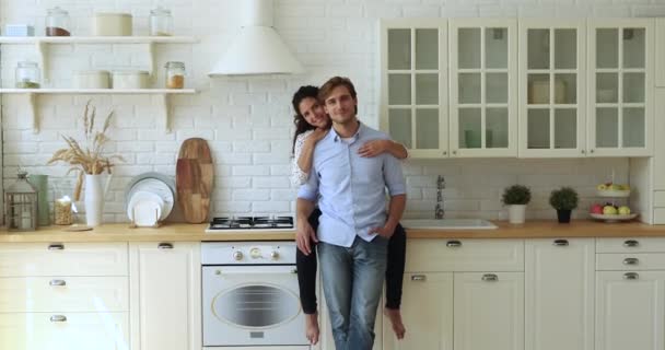 Fru sitta på kök bänkskiva kram make tittar på kameran — Stockvideo
