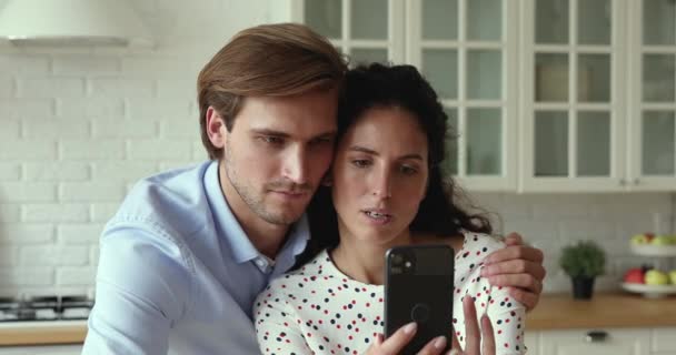 Happy couple using smartphone having fun together at home kitchen — Stock videók