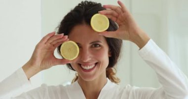 Limon dilimleri tutan kadın kameraya bakıyor.