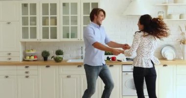Mutlu evli çift modern mutfakta müzik dinliyor.