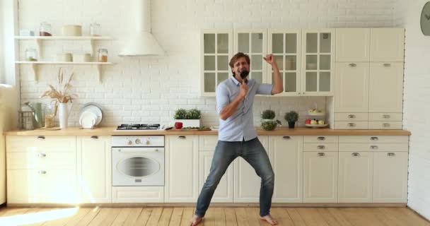 Hombre cantando bailando descalzo en suelo radiante suelo radiante en la cocina — Vídeos de Stock