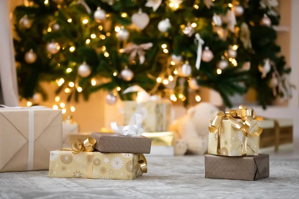 Zabalené vánoční dárky pod zdobenou jedlí — Stock fotografie