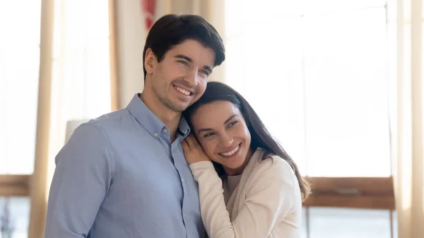 Feliz recién casados abrazándose en nuevo apartamento y soñando con el futuro —  Fotos de Stock