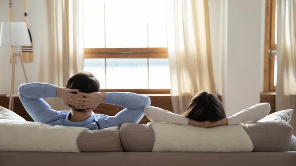 Millennial family resting on sofa in luxurious hotel