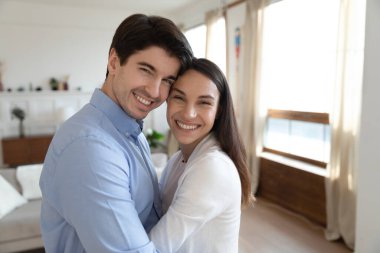 Yeni evliler yeni evlerinde portre için poz veriyorlar.