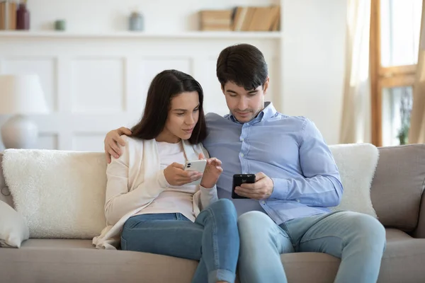 Jeune couple amoureux utilisant des gadgets ensemble partager des informations intéressantes — Photo