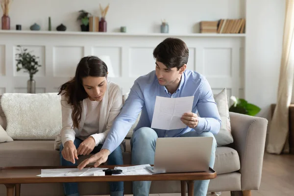 Konzentriert diskutieren aufmerksame Millennial-Ehepartner über die Möglichkeit, einen Bankkredit aufzunehmen — Stockfoto