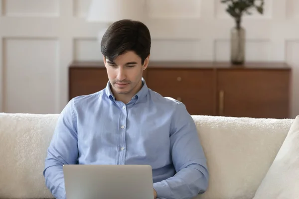 Geconcentreerde jonge man freelancer werken vanuit huis op laptop — Stockfoto
