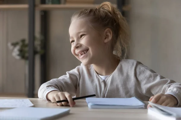 Overjoyed motivated little girl studying, doing school homework — Stock Photo, Image