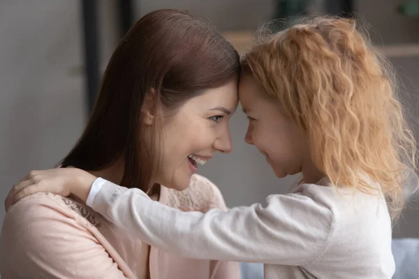 Närbild överlycklig mor och bedårande dotter röra pannan — Stockfoto