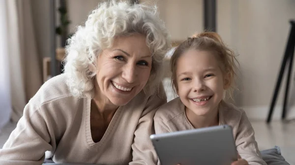 Potret kepala wanita dewasa tersenyum dengan cucu menggunakan tablet — Stok Foto