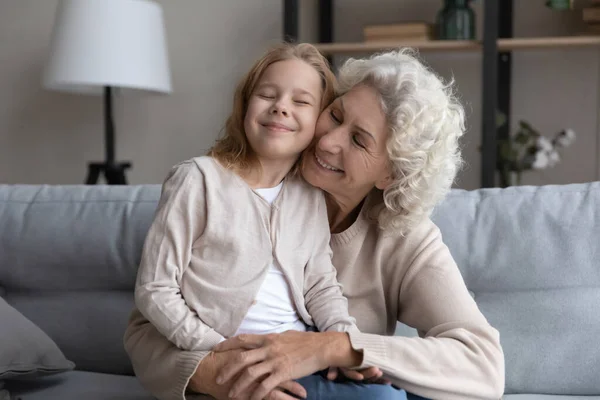 漂亮的小女孩坐在快乐而成熟的祖母身边 — 图库照片