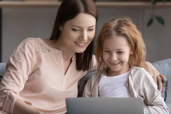 Close up smiling young woman with little girl using laptop