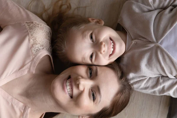 Mutter und kleine Tochter lächelnd auf dem Boden liegend — Stockfoto