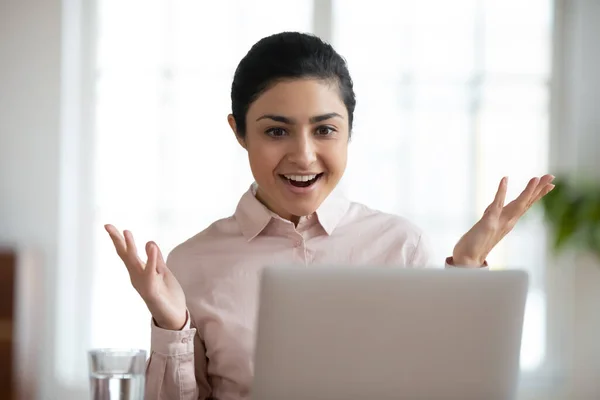 Excited young ethnic woman stunned by good news on laptop — Stock Photo, Image