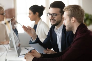 Çeşitli erkek meslektaşlar birlikte çalışma ofisinde işbirliği yaparlar.