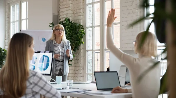 Female employee raise hand participate in discussion at meeting — Stock Photo, Image